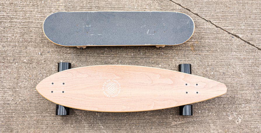 skateboard next to longboard - concrete background